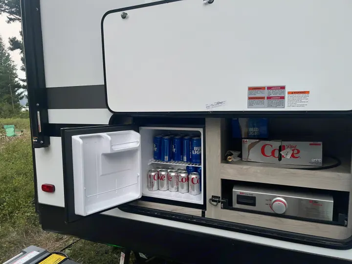 An RV rental's outdoor kitchen features a mini-fridge with drinks and a pull-out Suburban griddle for convenient campsite cooking.. Connect SE 2022