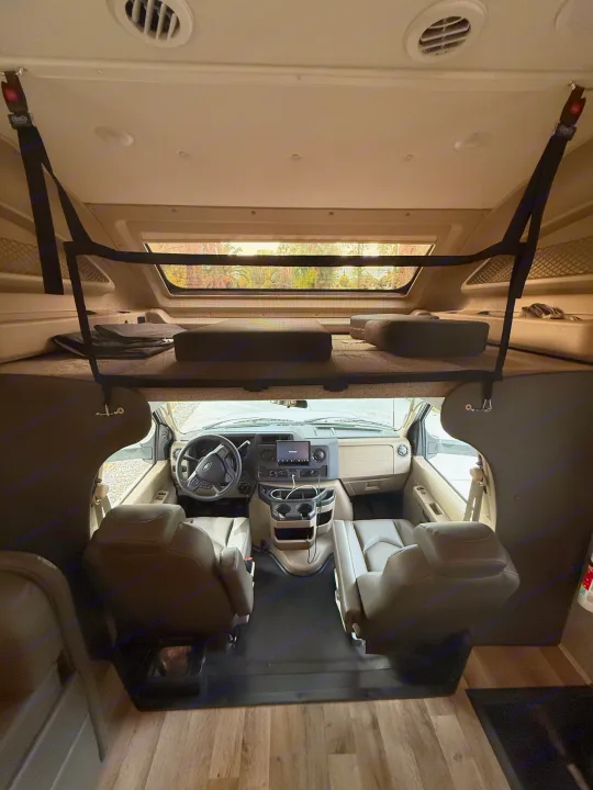 Spacious RV rental interior: overhead bunk, driver's cockpit, and front seats, ready for adventure.. Jayco Greyhawk 2023
