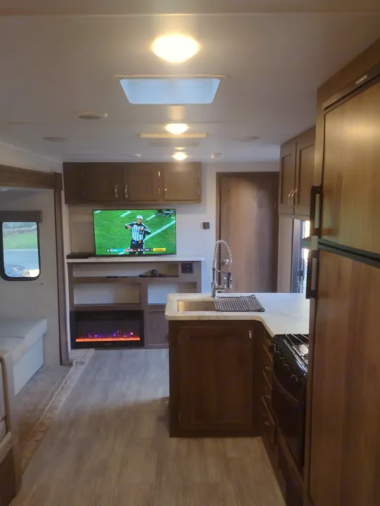 This RV rental offers a cozy interior with a TV, fireplace, full kitchen, and comfortable living space, perfect for your next trip.. East to West Silver Lake 2021