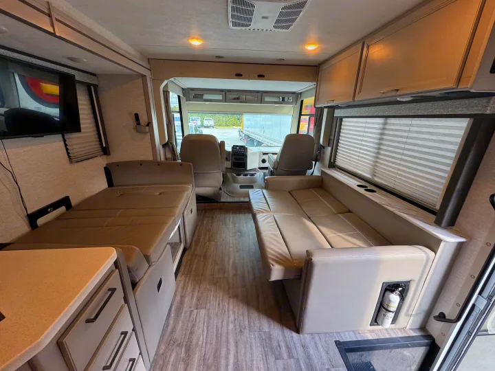 Spacious, modern RV rental interior with a living area, convertible bed, sofa, and front cockpit, ready for adventures.. Thor Resonate 2024