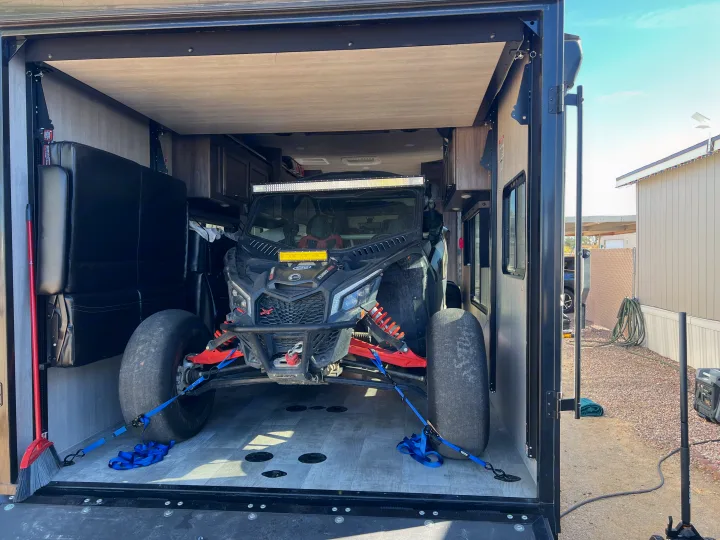 Adventure awaits! This toy hauler RV rental securely transports an off-road UTV, ready for your next trip.. Genesis Supreme Rv Genesis Supreme 2022
