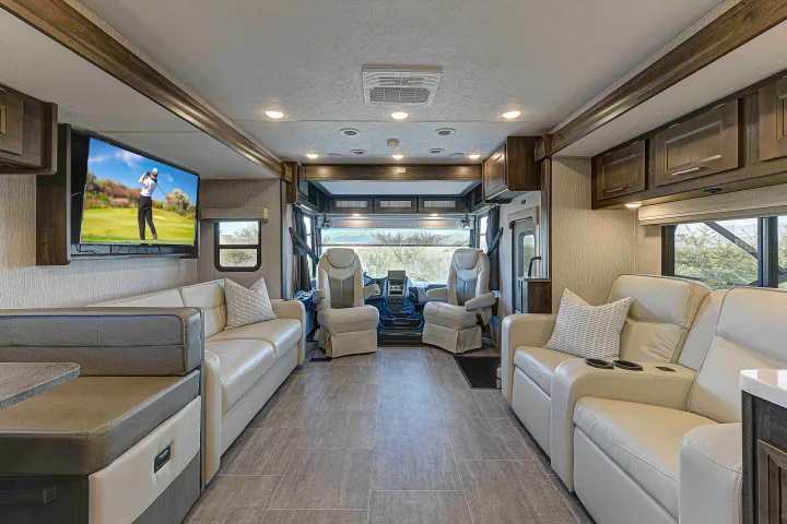Spacious RV rental interior: comfortable lounge, TV, and accessible cockpit. Ideal for road trips.. Coachmen Mirada 35OS 2023
