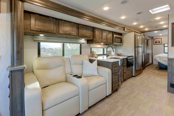 Spacious RV rental interior featuring recliners, a full kitchen, and scenic window views.. Coachmen Mirada 35OS 2023