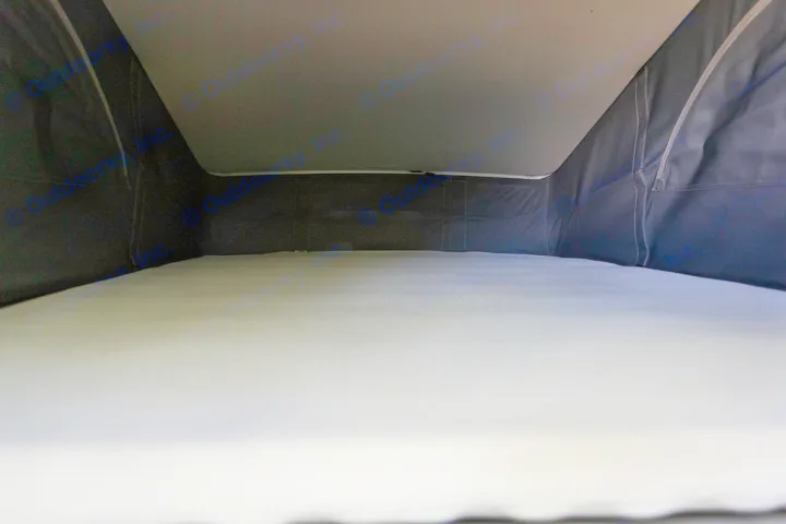 Cozy RV rental pop-top sleeping area with a comfortable mattress, featuring dark fabric walls and a light ceiling.. Volkswagen California Coast T6 2020