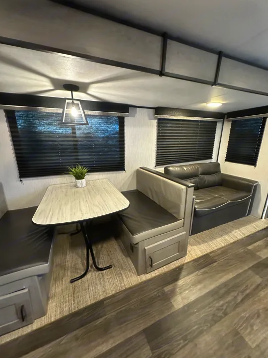 Inviting RV rental interior: modern dinette, comfy sofa, sleek wood floors, and soft lighting.. Heartland RVs Mallard 2022
