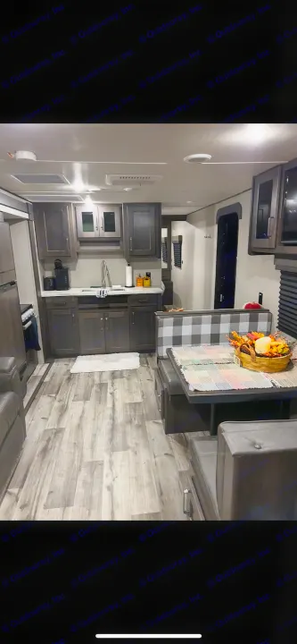 Cozy RV rental: modern kitchen, checkered dinette with fall decor, wood floors. Perfect for your next adventure!. Grand Design Transcend Xplor 2024