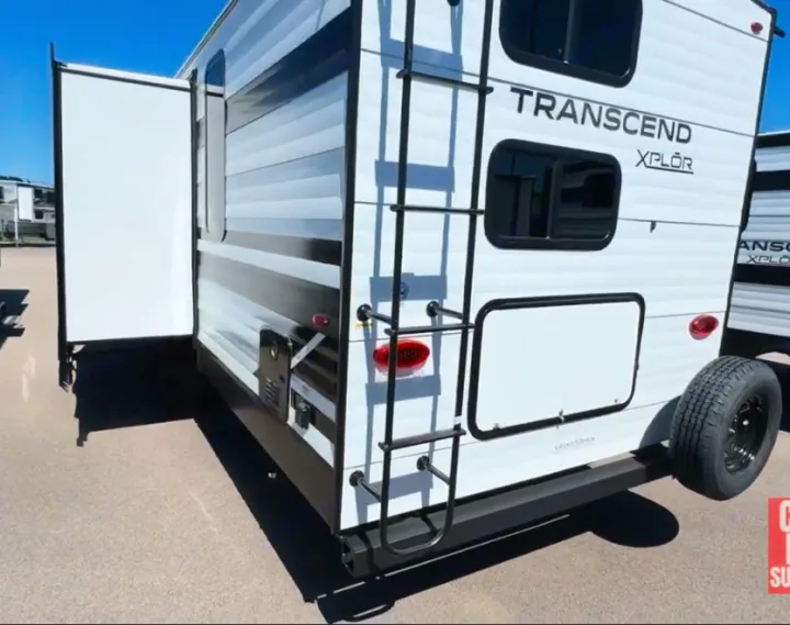 This white Transcend Xplor RV rental features an extended slide-out, rear ladder, and spare tire, ideal for travel.. Grand Design Transcend Xplor 2024