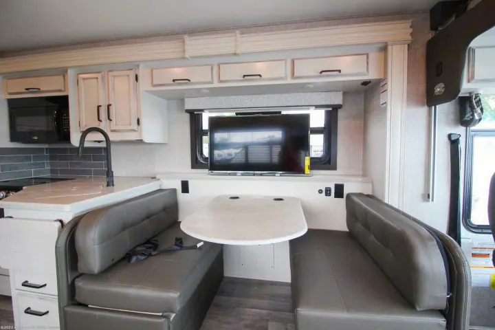 Spacious RV rental kitchen and dinette with TV, sink, microwave, and ample seating.. Entegra Coach 29F 2021