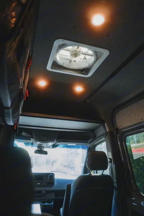 Inside an RV rental: view of the ceiling with a fan, bright lights, and front cabin. Perfect for your next road trip adventure!. Mercedes-Benz Sprinter 2022