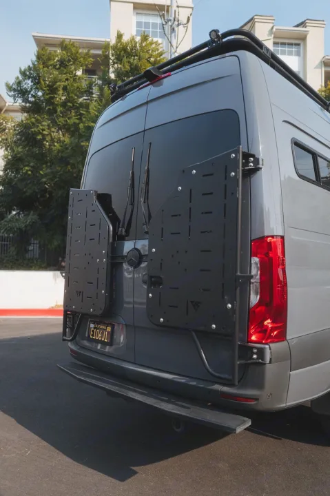 Rear of a custom gray camper van, showcasing modular gear panels, roof rack, and a step bumper. Ready for RV rental.. Mercedes-Benz Sprinter 2022