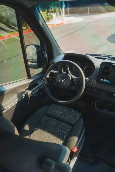 Inside a Mercedes-Benz RV rental: driver's view of the dashboard, steering wheel, and front seat.. Mercedes-Benz Sprinter 2022