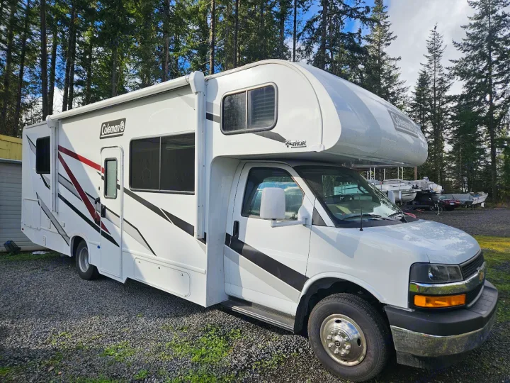 Spacious white Coleman Class C RV on gravel. Perfect for your next RV rental trip, camping, or family adventure.. Thor Coleman 28AMC 2024