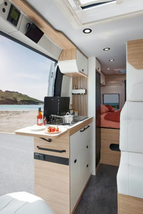 Cozy RV rental interior with modern kitchen, comfortable bed, and stunning beach view. Ideal for road trips.. Pilote V600G EVIDENCE 2025