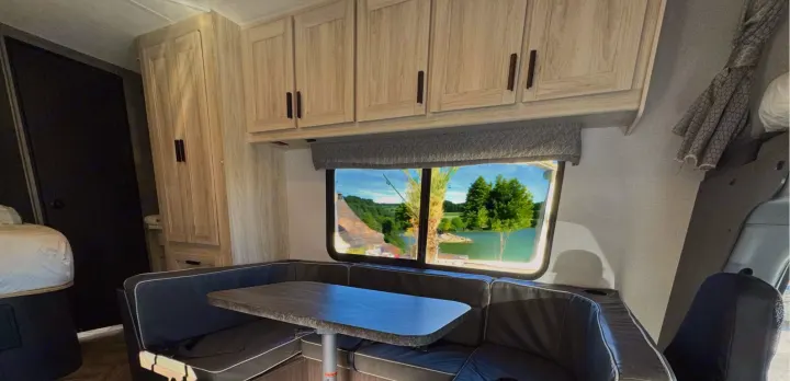 Experience comfort in this rv rental. Features a spacious dinette, overhead storage, and a picturesque lake view.. Forest River Forester 2022