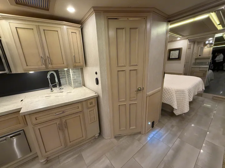 High-end RV rental interior showcasing a full kitchen, elegant cabinetry, and a comfortable bedroom suite.. Newmar Ventana 2020