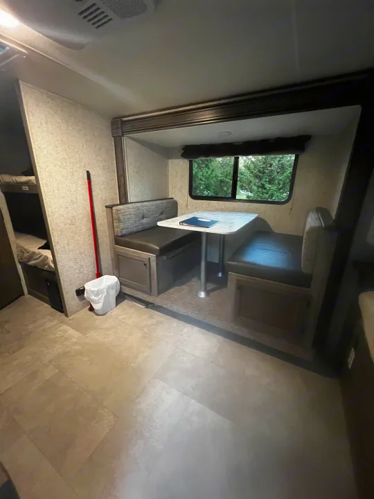 Cozy RV rental interior featuring a dinette, bunk beds to the left, and a window showcasing nature.. Apex Nano 193 BHS 2020
