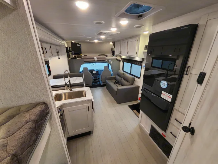 Modern RV rental interior with a spacious kitchen, dinette, and comfortable living area for your next adventure.. East To West Entrada 2025