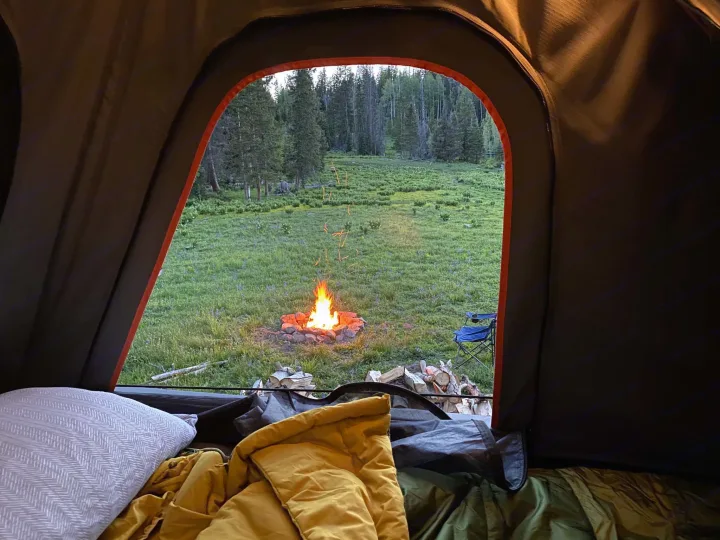 Experience tranquil nature from your cozy RV rental! A warm campfire glows in a lush meadow, surrounded by a serene forest.. Toyota 4Runner 2024