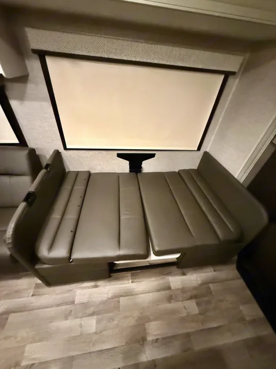 Spacious RV rental dinette converts to a comfy bed. Enjoy movie nights with the built-in screen!. Jayco Greyhawk 2023