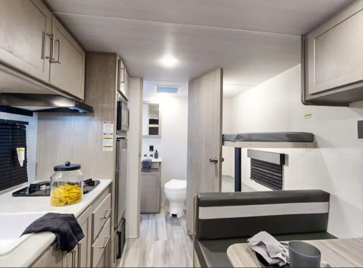 Step inside this RV rental, featuring a full kitchen, compact bathroom, dinette, and cozy bunk beds for your travels.. Keystone RV Springdale 2024