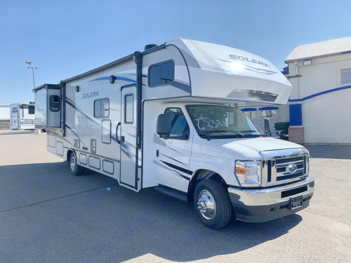 Bright white and grey Solera Class C RV rental, a motorhome with a slide-out, parked on a sunny day.. Forest River Solera 2022