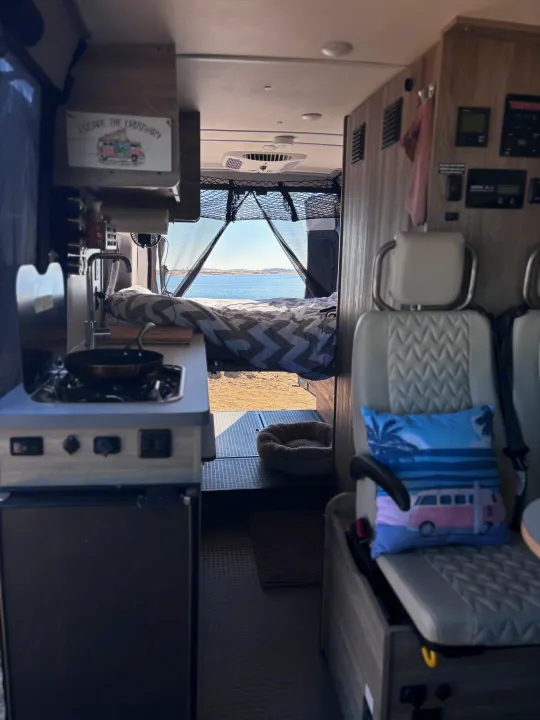 Cozy rv rental interior: kitchen, lake-view bed, and dog bed. 'Escape the Ordinary' van life awaits.. Winnebago Winnebago 2024