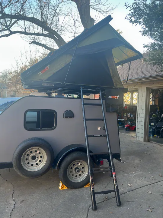 A grey teardrop camper trailer with a 23ZERO roof-top tent and ladder. Great option for RV rental adventures.. Little Guy Other 2020
