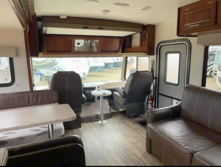 Spacious RV rental interior featuring a dinette, sofa, and front cabin with swivel seats. Wood-look floors visible.. FR3 FR3 Motorhome 2017
