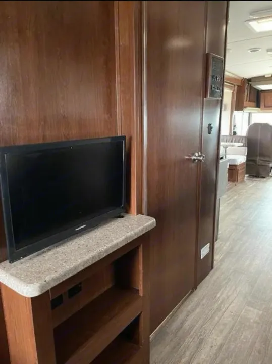 Inside an RV rental: a modern living space featuring a TV, storage, and a glimpse of the comfortable dinette.. FR3 FR3 Motorhome 2017