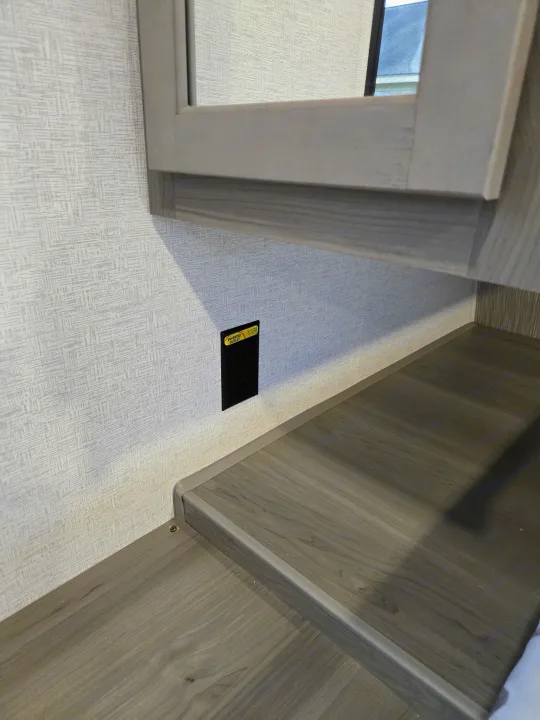 RV rental interior with an 'INVERTED OUTLET' (Solar Flex labeled) on the wall above a wood-grain counter.. Keystone Hideout 240BH 2025