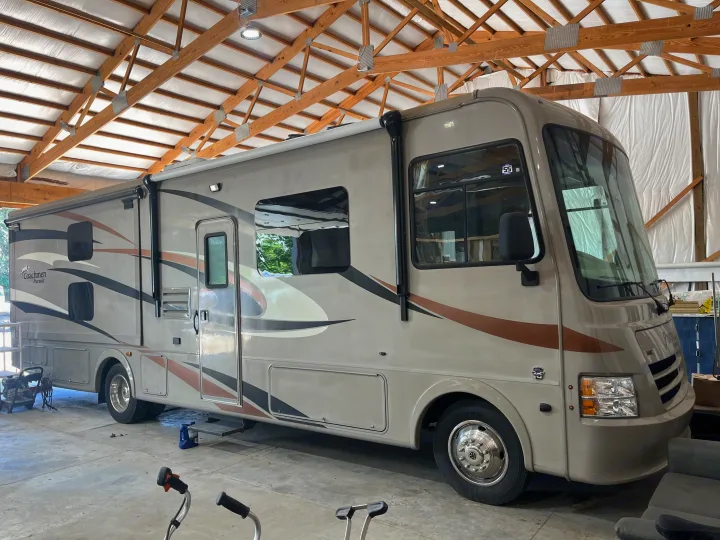 Spacious Coachmen Pursuit RV rental parked indoors under a timber roof, ready for your next adventure.. Forest River Coachmen Pursuit 2017