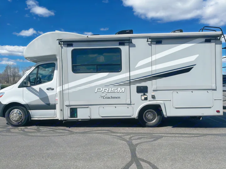 This grey and white Coachmen Prism motorhome, perfect for your next rv rental adventure, parked under a blue sky.. Coachmen Prism 2022