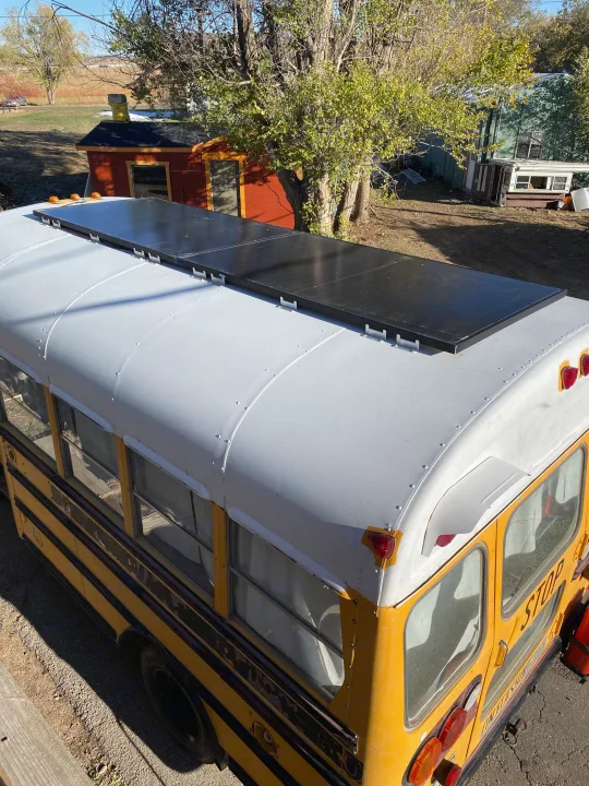 Top-down view of a yellow school bus RV conversion, featuring rooftop solar panels, ideal for an RV rental.. GMC Vandura 1986