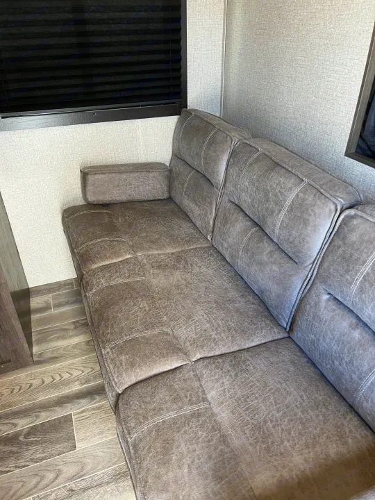 RV rental: Gray, textured sofa with white stitching, black blinds, and wood-look floor in the living area.. Jayco Jay Flight SLX Rocky Mountain Edition 2020