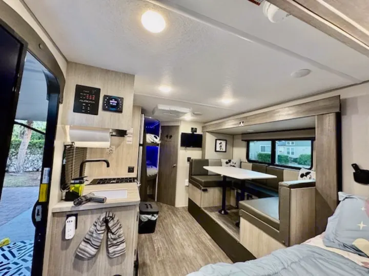 Spacious and modern RV rental interior featuring a compact kitchen, dining area, and cozy sleeping space.. Forest river Aurora 2025