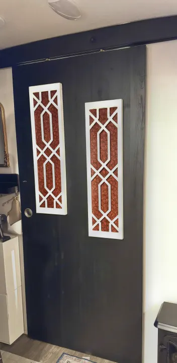 Barn-style sliding door with decorative panels inside an RV rental. Modern and space-saving interior design.. Heartland RVs Mallard 2024
