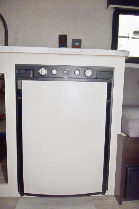 RV rental interior with a built-in Dometic refrigerator, countertop, and system controls.. Jayco Jay Flight SLX 2022