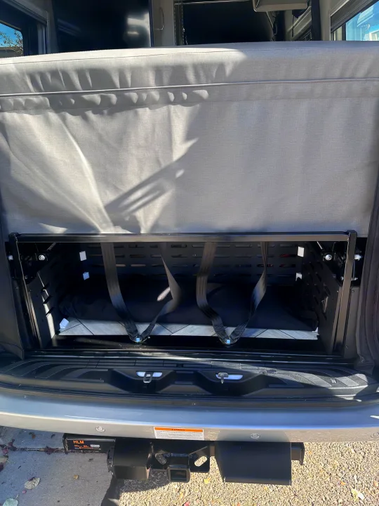 Inside an **RV rental**: rear cargo area with a modular storage system and tie-down straps for secure storage.. Thor Sanctuary 19P 2025