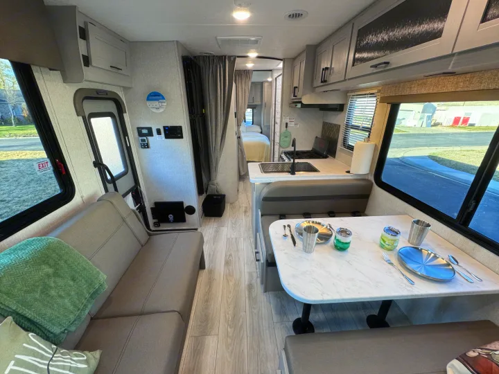 Modern rv rental interior: spacious kitchenette, dining area, and cozy seating visible throughout the living space.. Forest River Coachmen Freelander 2026