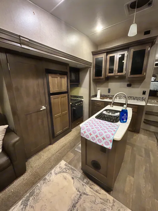 Experience an RV rental: modern kitchen with dark cabinetry, sink, stove, fridge, plus a living area with a sofa.. Forest River Flagstaff Super Lite 2019