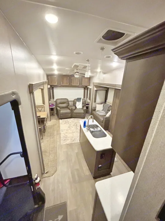 Cozy RV rental interior with living area, kitchen island, and dining space. Perfect for travel adventures.. Forest River Flagstaff Super Lite 2019