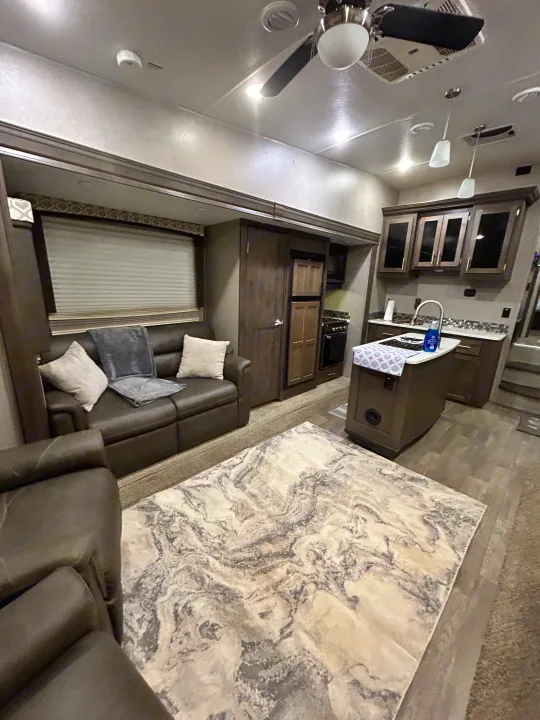 Spacious RV rental interior showcasing a modern living area, kitchen island, and comfortable seating for travelers.. Forest River Flagstaff Super Lite 2019