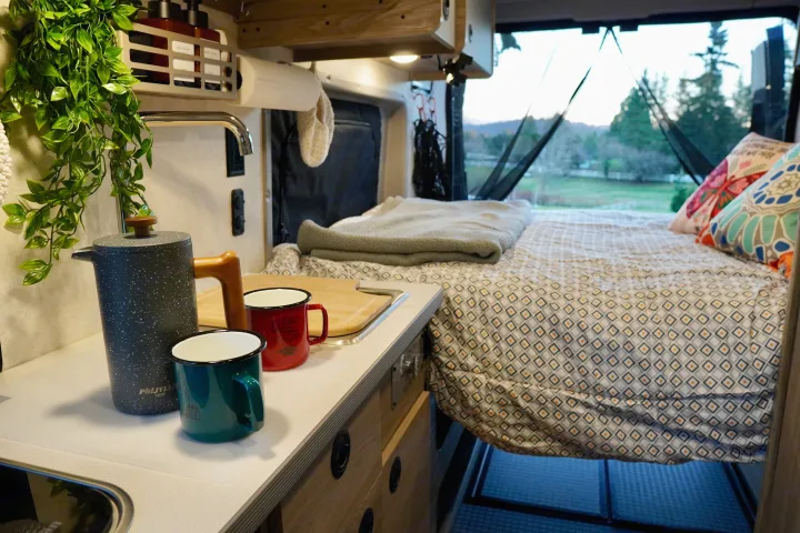 Cozy interior of an RV rental with kitchen area and comfortable bed, perfect for your next road trip adventure.. Winnebago Solis 59PX 2025