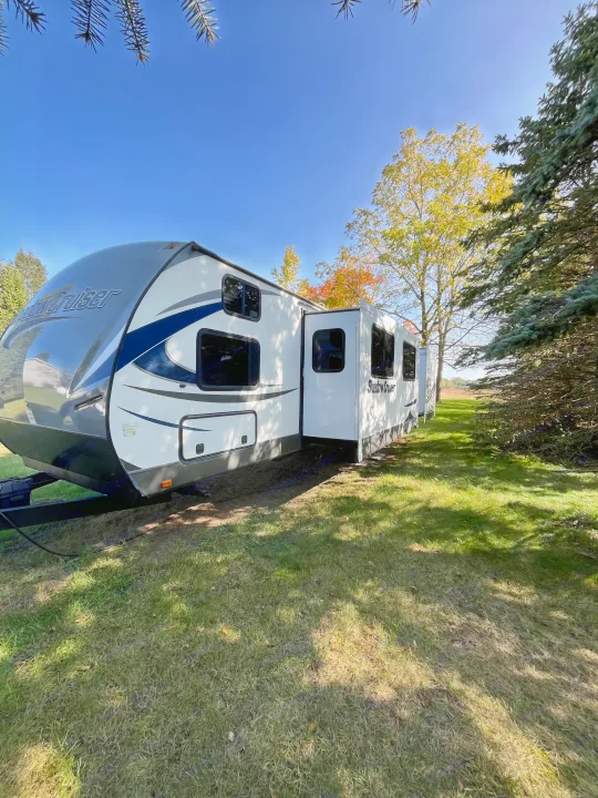 Spacious Shadow Cruiser travel trailer, an ideal rv rental, set on a sunny green lawn with surrounding trees.. Cruiser RV Shadow Cruiser 2015