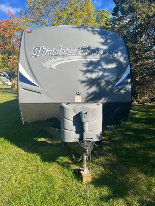 Grey Shadow Cruiser travel trailer, an RV rental, parked on sunny grass with trees in the background.. Cruiser RV Shadow Cruiser 2015