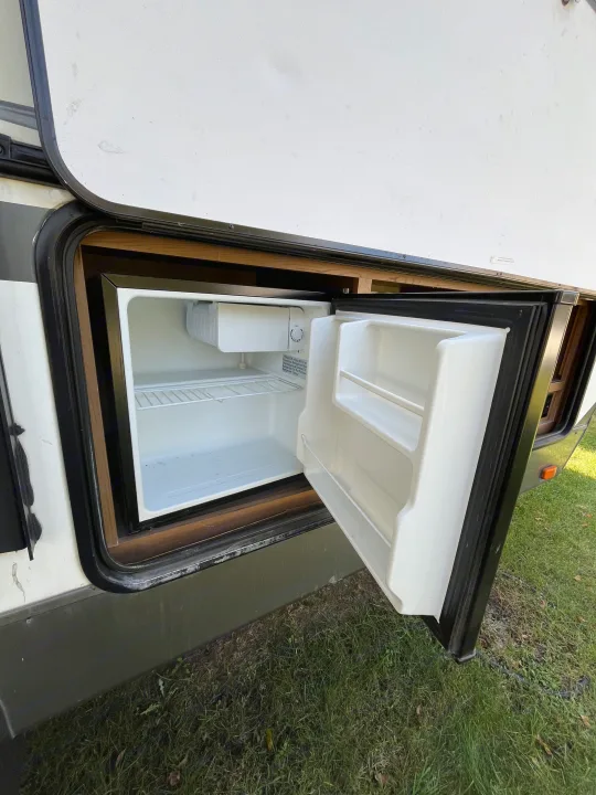 RV rental's exterior mini-fridge, open and ready for use. Ideal for keeping drinks and snacks cool on adventures.. Cruiser RV Shadow Cruiser 2015