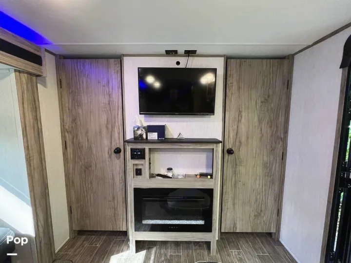 Modern RV rental interior: TV, fireplace, and ample storage for a comfortable journey.. Forest River Cherokee Alpha Wolf 2021