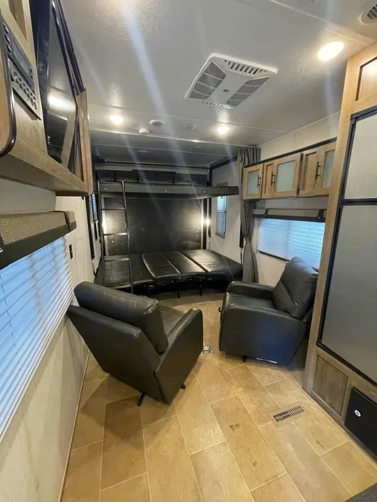 RV rental interior: Flexible space with fold-down beds, two recliners, AC, and storage cabinets.. Palomino Puma 2021