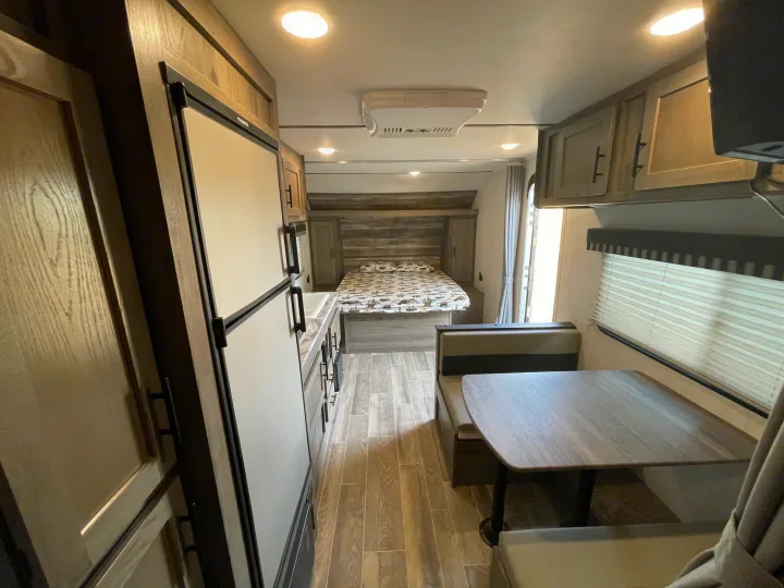 RV rental interior: A bright, modern living space featuring a bedroom, compact kitchen, and inviting dinette.. Gulf Stream Enlighten 2021