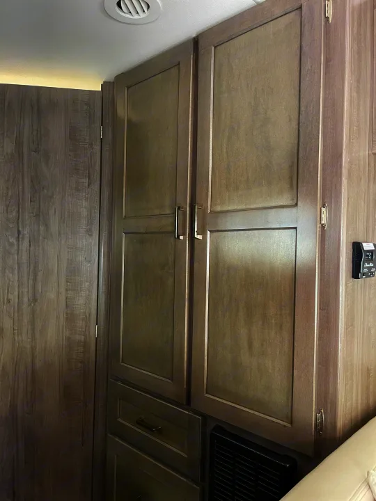 Inside an RV rental: a wall of modern gray wooden cabinets and a matching door, highlighting compact storage in a living space.. Winnebago Minnie Winnie 2019